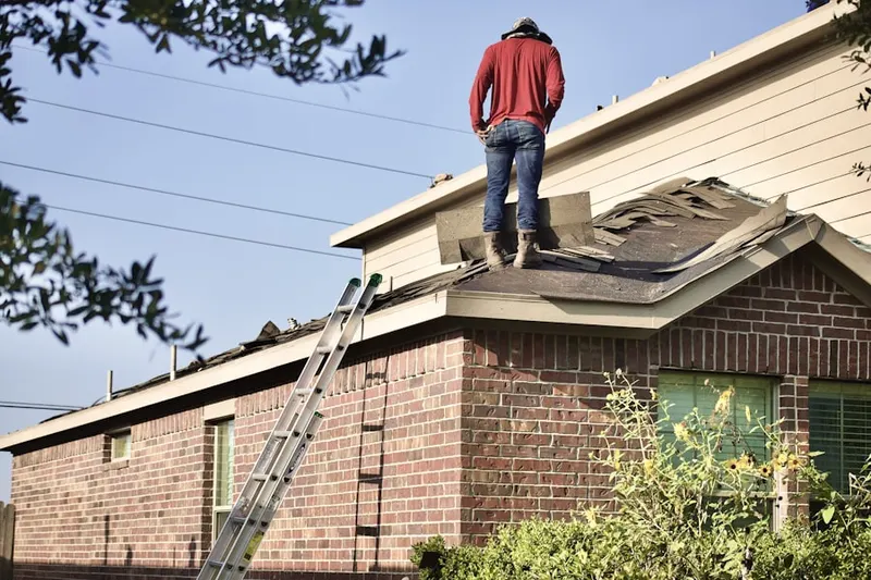 Professional roofer working on a residential roof in Vanderburg